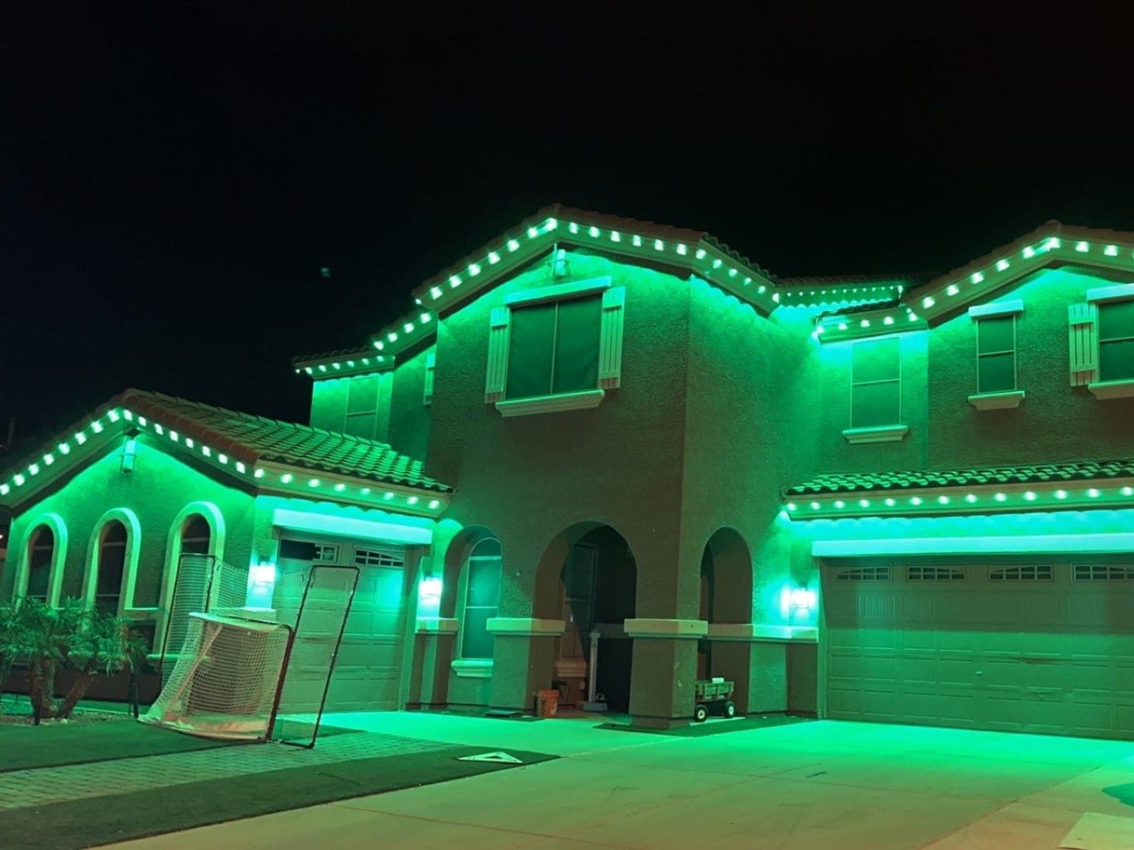 Large two-story home lit green along every roofline