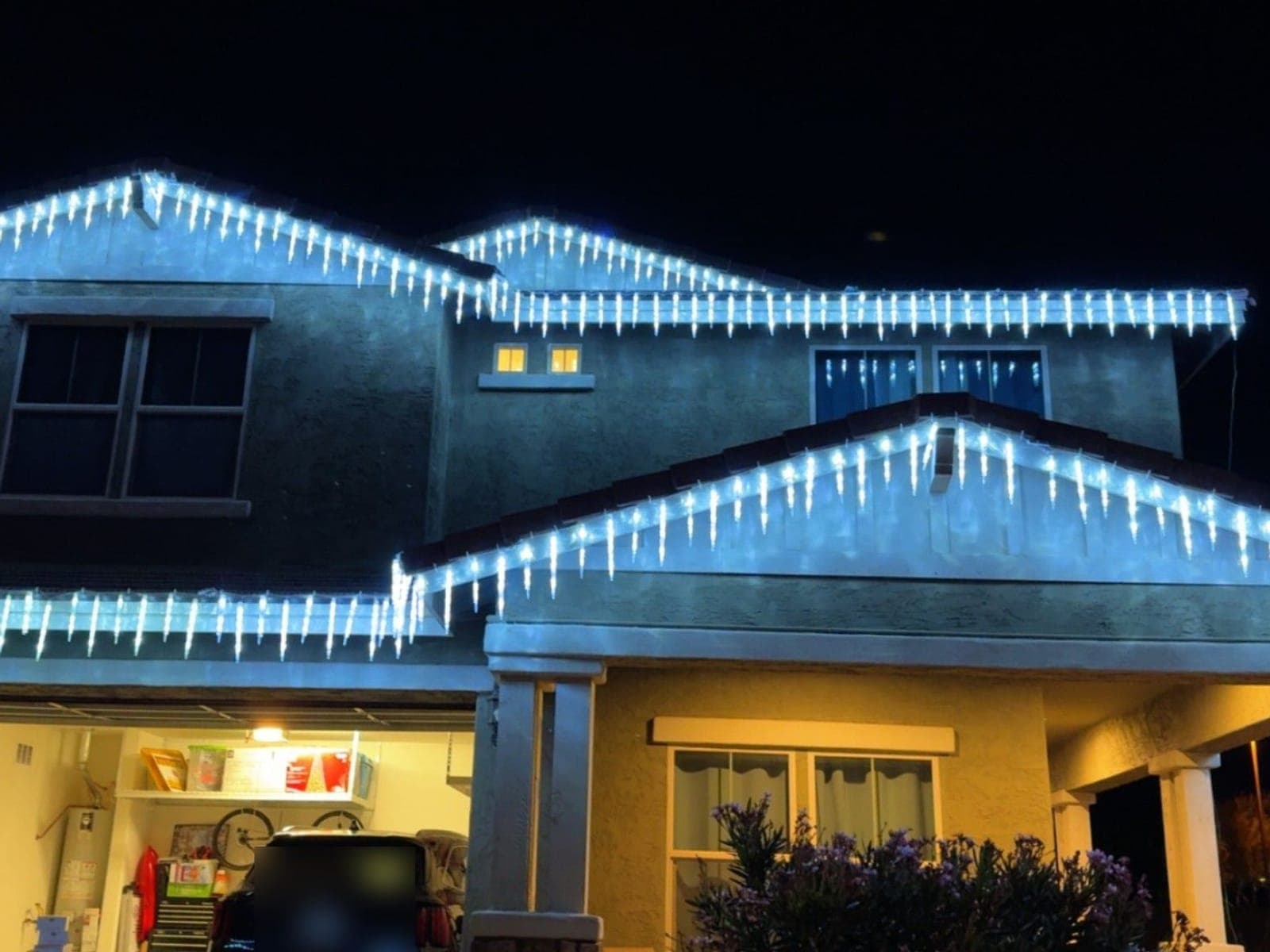 Two-story home with white icicle lights along each roofline
